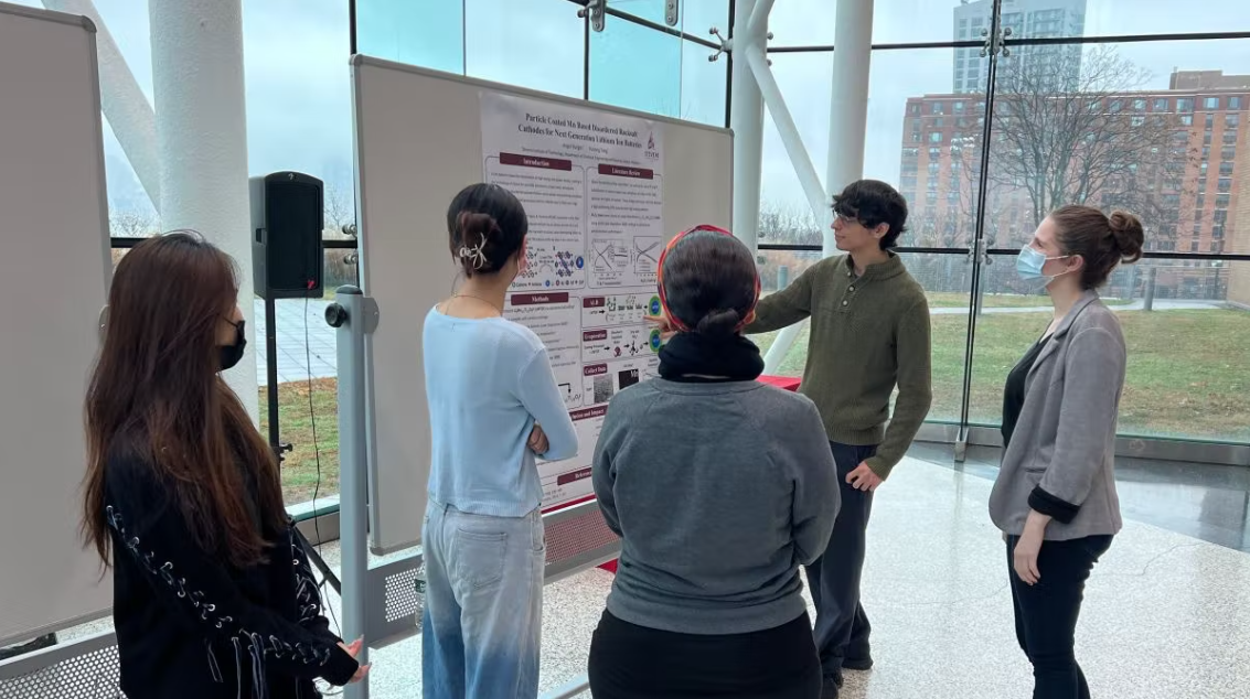 Sarah Goodman, wearing a mask, works with with students at MT 650: Special Topics in Materials Science and Engineering.